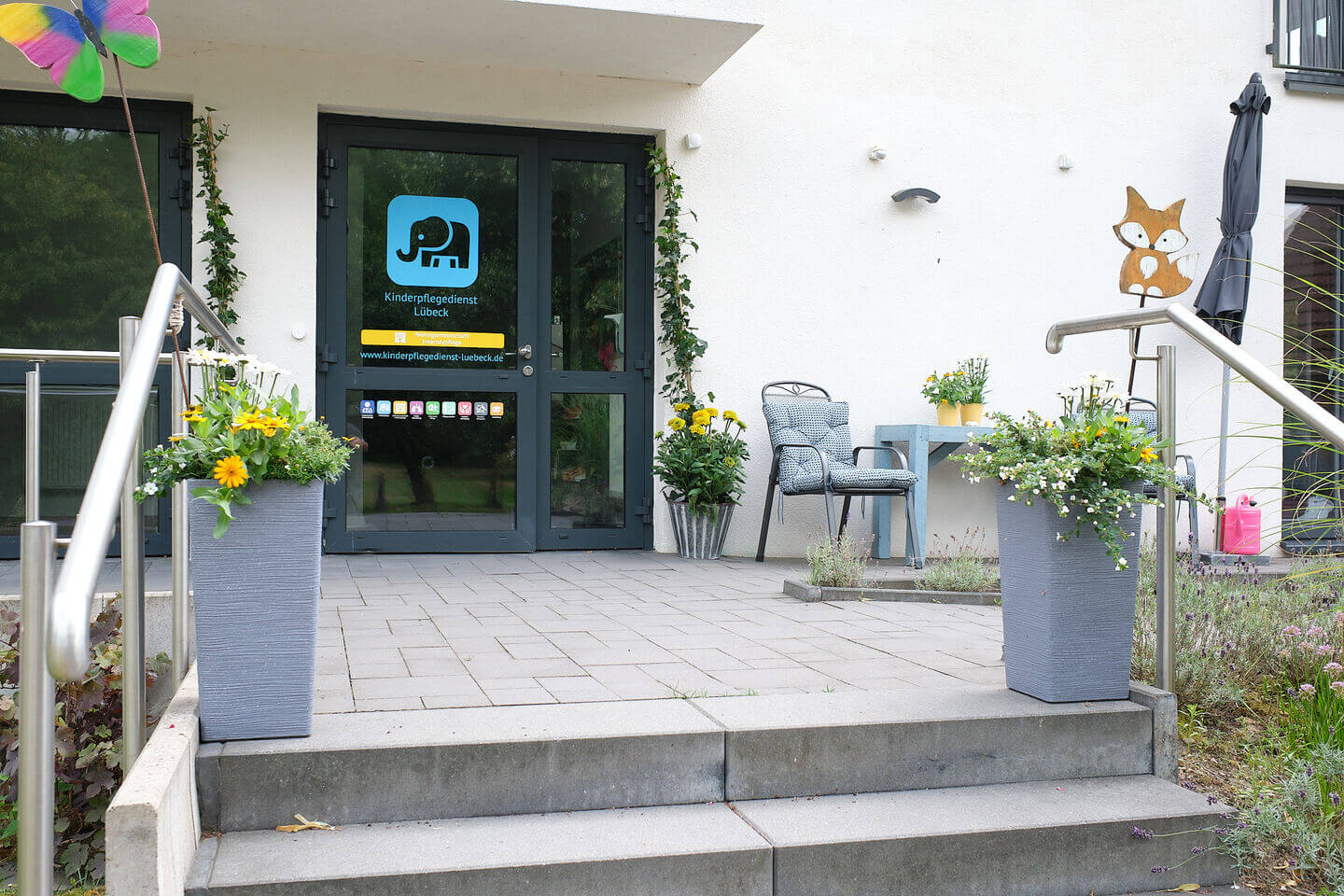 Einladender Eingangsbereich der Wohngruppe Dörnick mit bunten Blumen und barrierefreiem Zugang