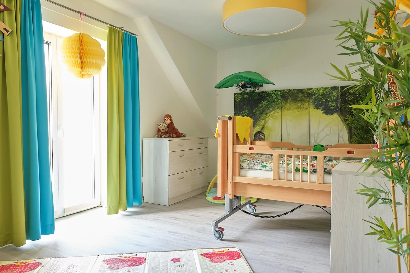 Lichtdurchflutetes Pflegezimmer mit Spielbereich und Blick ins Grüne